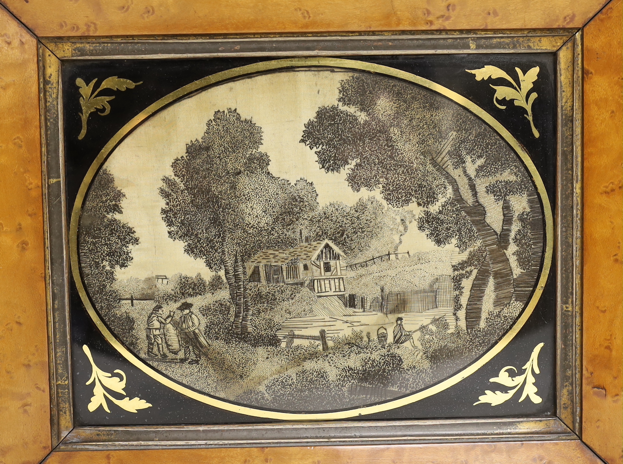 A pair of maple framed and oval verre eglomise glass Regency black silk embroidered pictorial landscape panels, 19cm wide x 14cm high